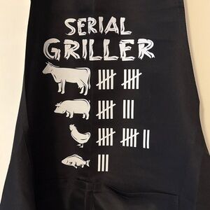 Apron Black 'Serial Griller'  front pockets with adjustable neck straps. Ties